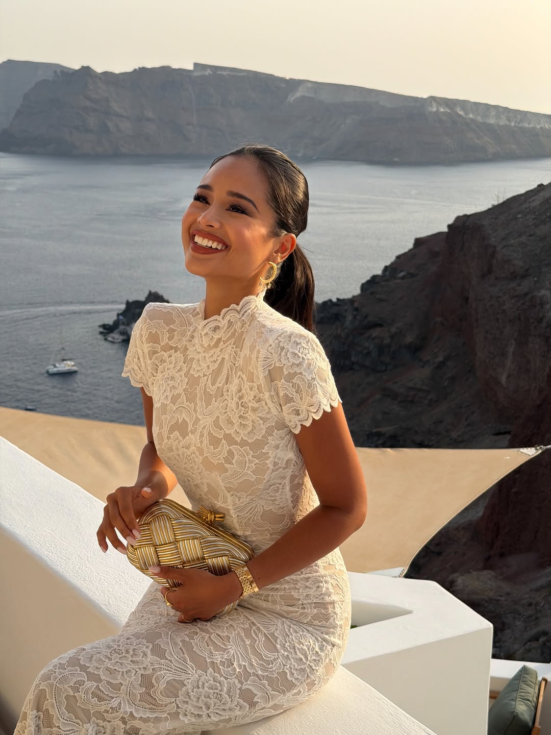 Portrait of Pat Chaveesak (Jarinpat) smiling, in a cream lace dress, Santorini
