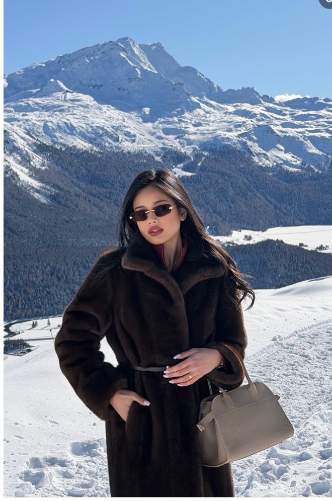 Pat Chaveesak (jarinpat) in a fur coat above snowy peaks, apres-ski style