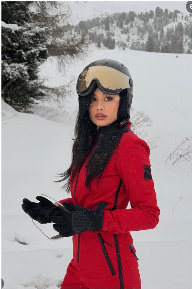 Pat Chaveesak (jarinpat) in a red ski suit in the snow, alpine winter editorial